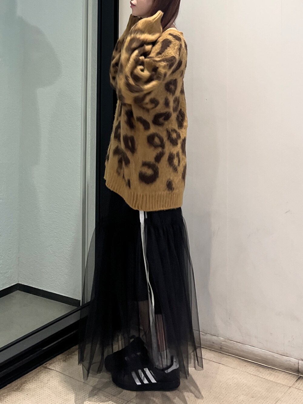 ブラウン系のニット/セーター、ブラック系のスカートを着用したレディースの秋コーディネートの2枚目の写真