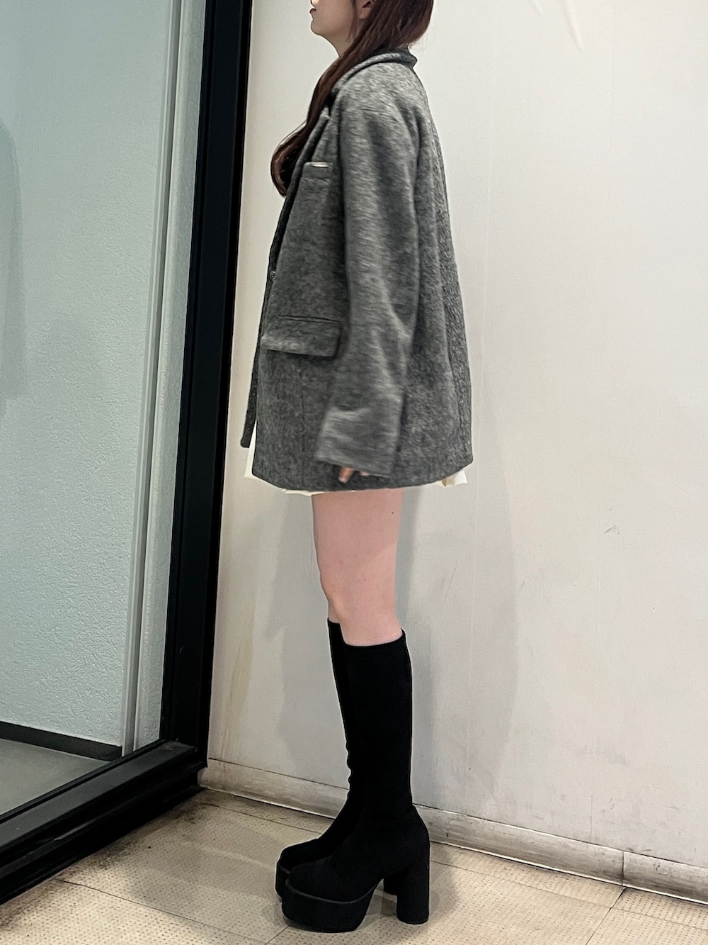 ホワイト系のスカート、グレー系のテーラードジャケット、ブルー系のニット/セーターを着用したレディースの秋コーディネートの2枚目の写真