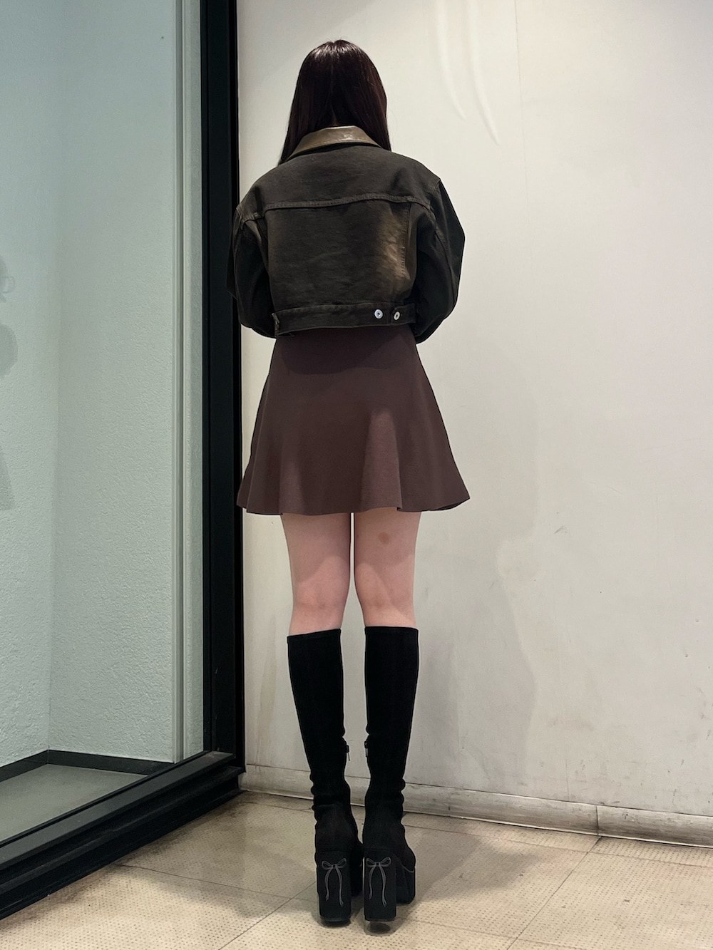 ブラウン系のワンピース、ブラック系のデニムジャケット、ブラック系のブーツを着用したレディースの秋コーディネートの3枚目の写真