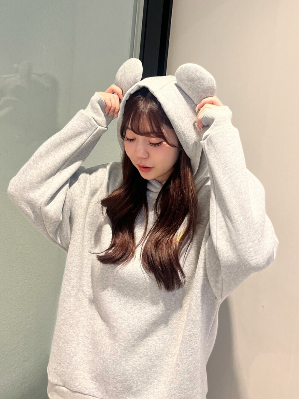 ホワイト系のパンプス、グレー系のスウェット、ブルー系のデニムパンツを着用したレディースの秋コーディネートの4枚目の写真