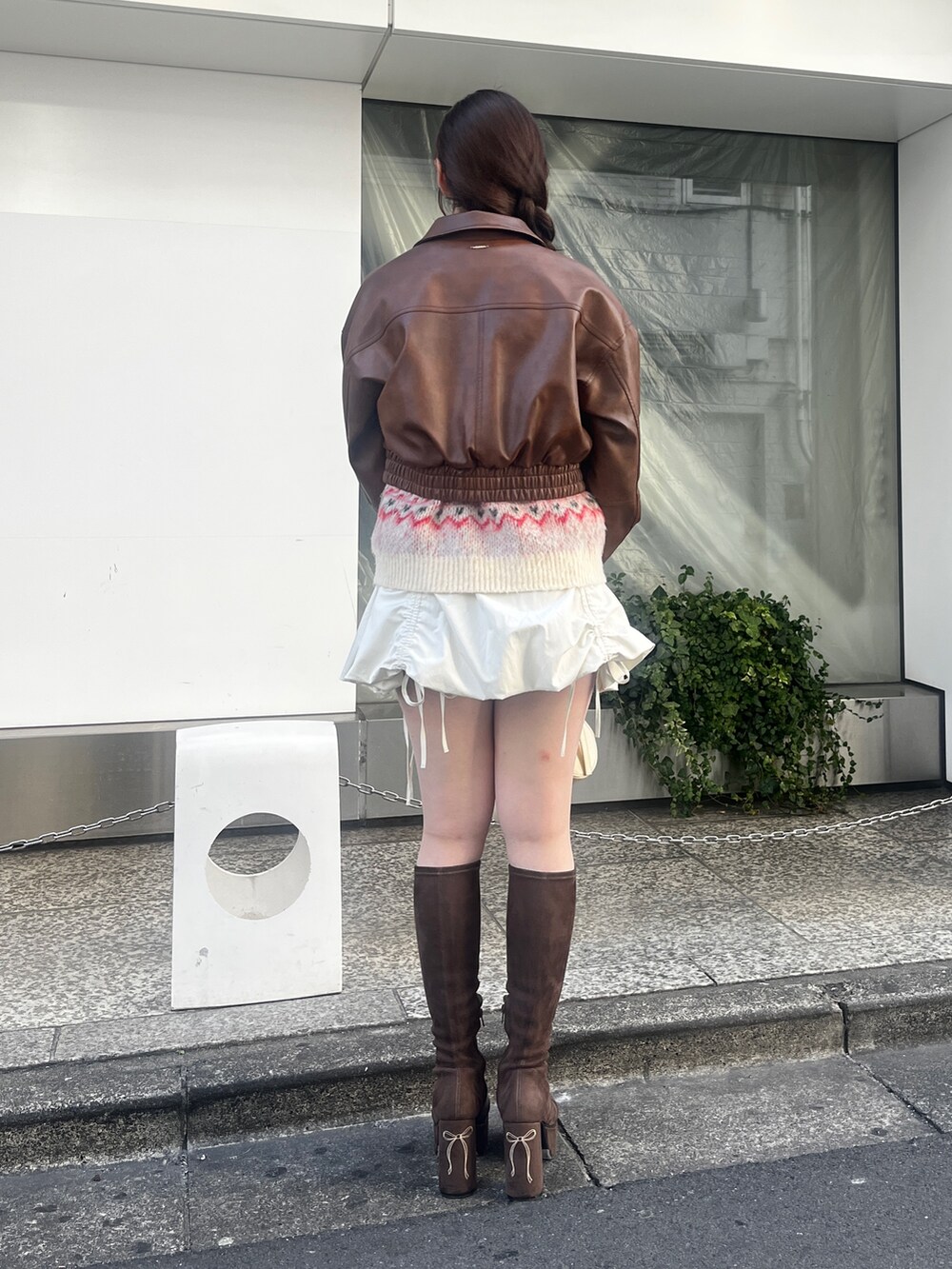 ブラウン系のブルゾン、ホワイト系のニット/セーター、ホワイト系のスカートを着用したレディースの冬コーディネートの3枚目の写真