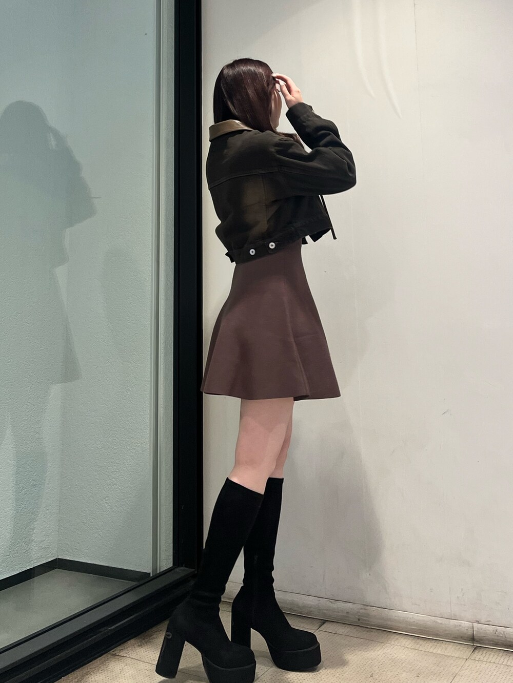ブラウン系のワンピース、ブラック系のデニムジャケット、ブラック系のブーツを着用したレディースの秋コーディネートの2枚目の写真