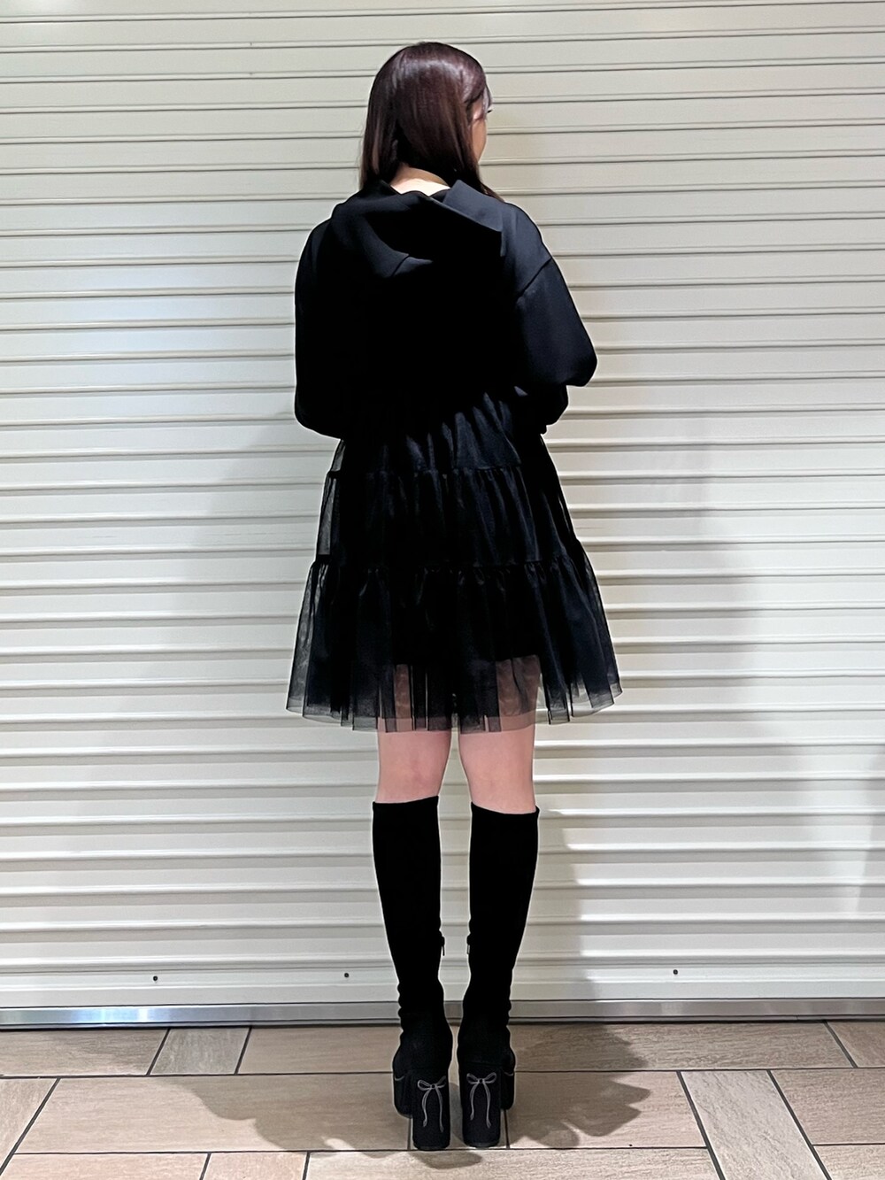 ブラック系のワンピース、ブラック系のブーツを着用したレディースの秋コーディネートの3枚目の写真