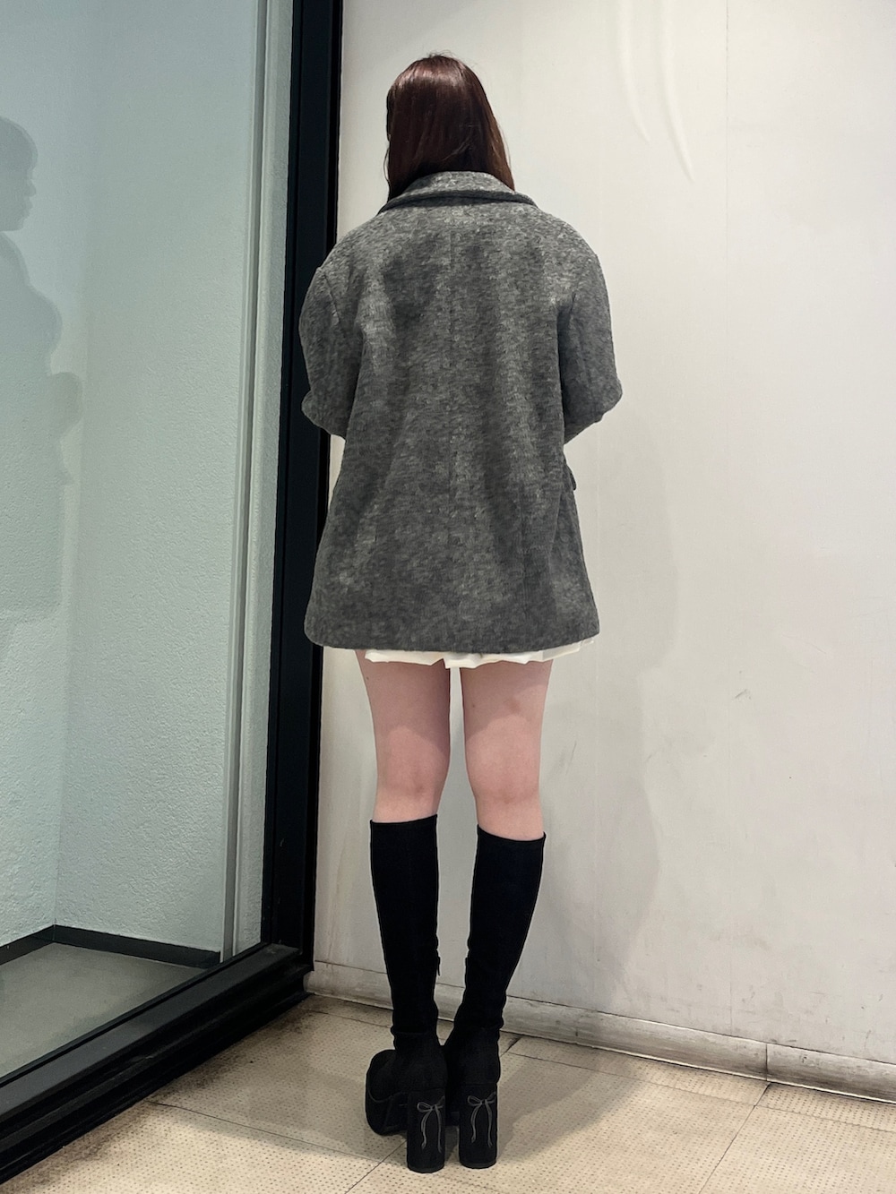 ホワイト系のスカート、グレー系のテーラードジャケット、ブルー系のニット/セーターを着用したレディースの秋コーディネートの3枚目の写真