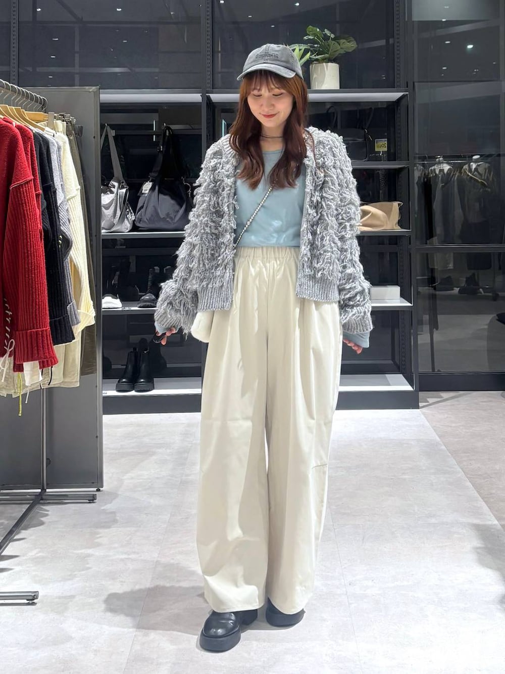 ブラック系のサンダル、ブルー系のTシャツ/カットソー、グレー系のニット/セーターを着用したレディースの秋コーディネートの2枚目の写真