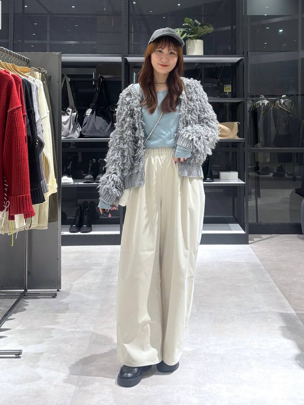 ブラック系のサンダル、ブルー系のTシャツ/カットソー、グレー系のニット/セーターを着用したレディースの秋コーディネートの4枚目の写真