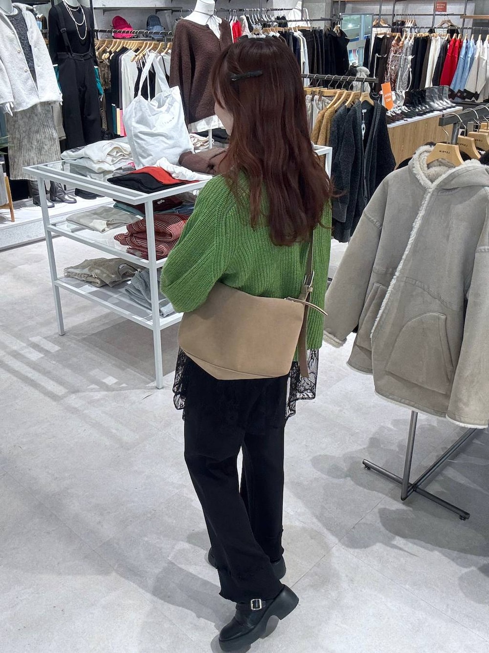 ベージュ系のショルダーバッグ、ブラック系のサンダル、ブラック系のブルゾンを着用したレディースの冬コーディネートの3枚目の写真