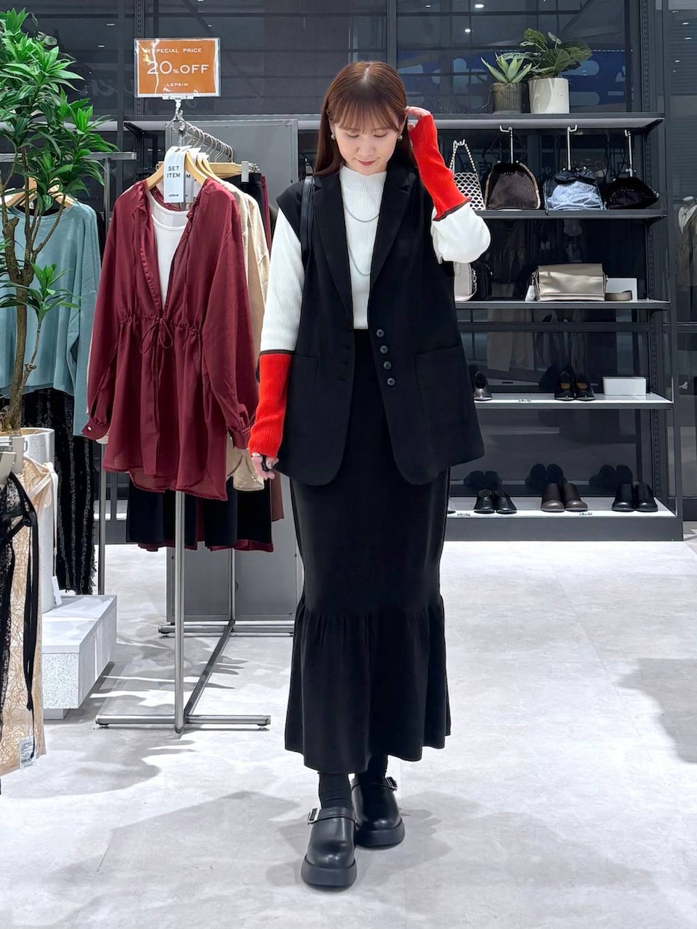 ブラック系のスカート、ホワイト系のニット/セーター、ブラック系のサンダルを着用したレディースの秋コーディネートの5枚目の写真