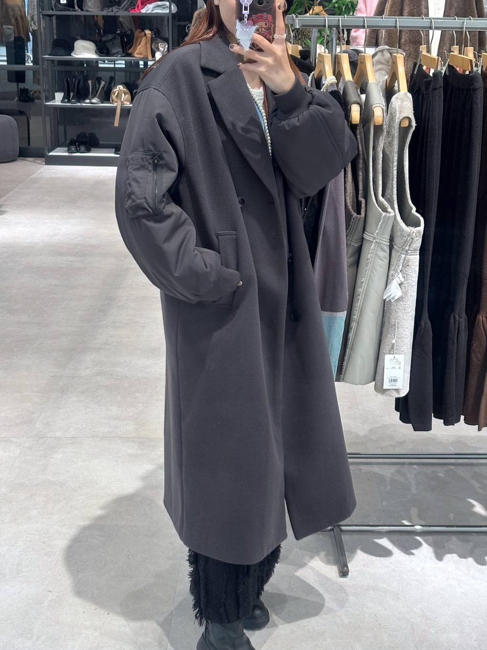 ブラック系のスカート、ブルー系のカーディガン/ボレロ、グレー系のその他アウターを着用したレディースの秋コーディネートの3枚目の写真