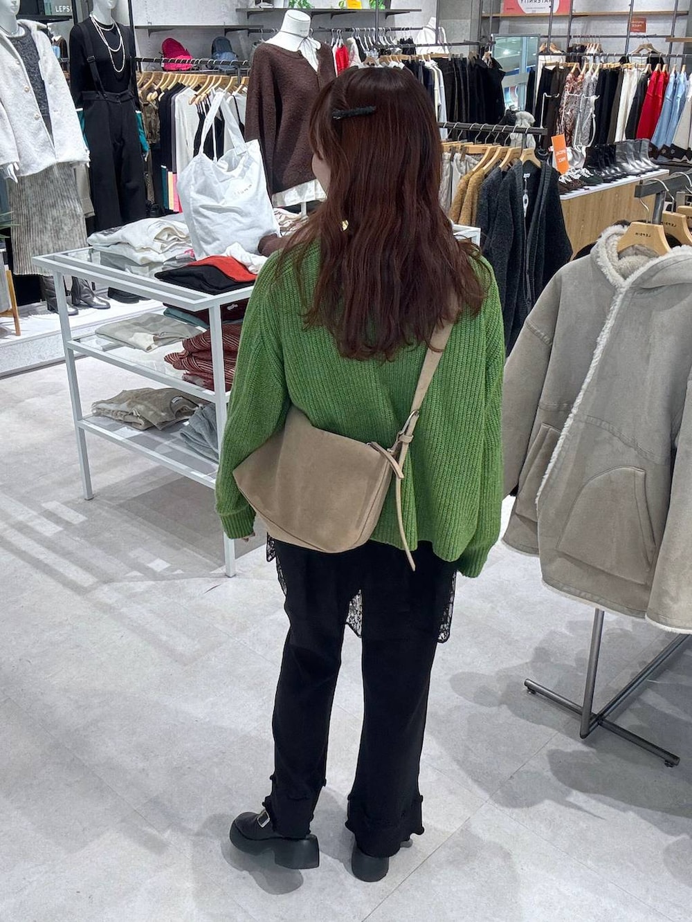 ベージュ系のショルダーバッグ、ブラック系のサンダル、ブラック系のブルゾンを着用したレディースの冬コーディネートの4枚目の写真