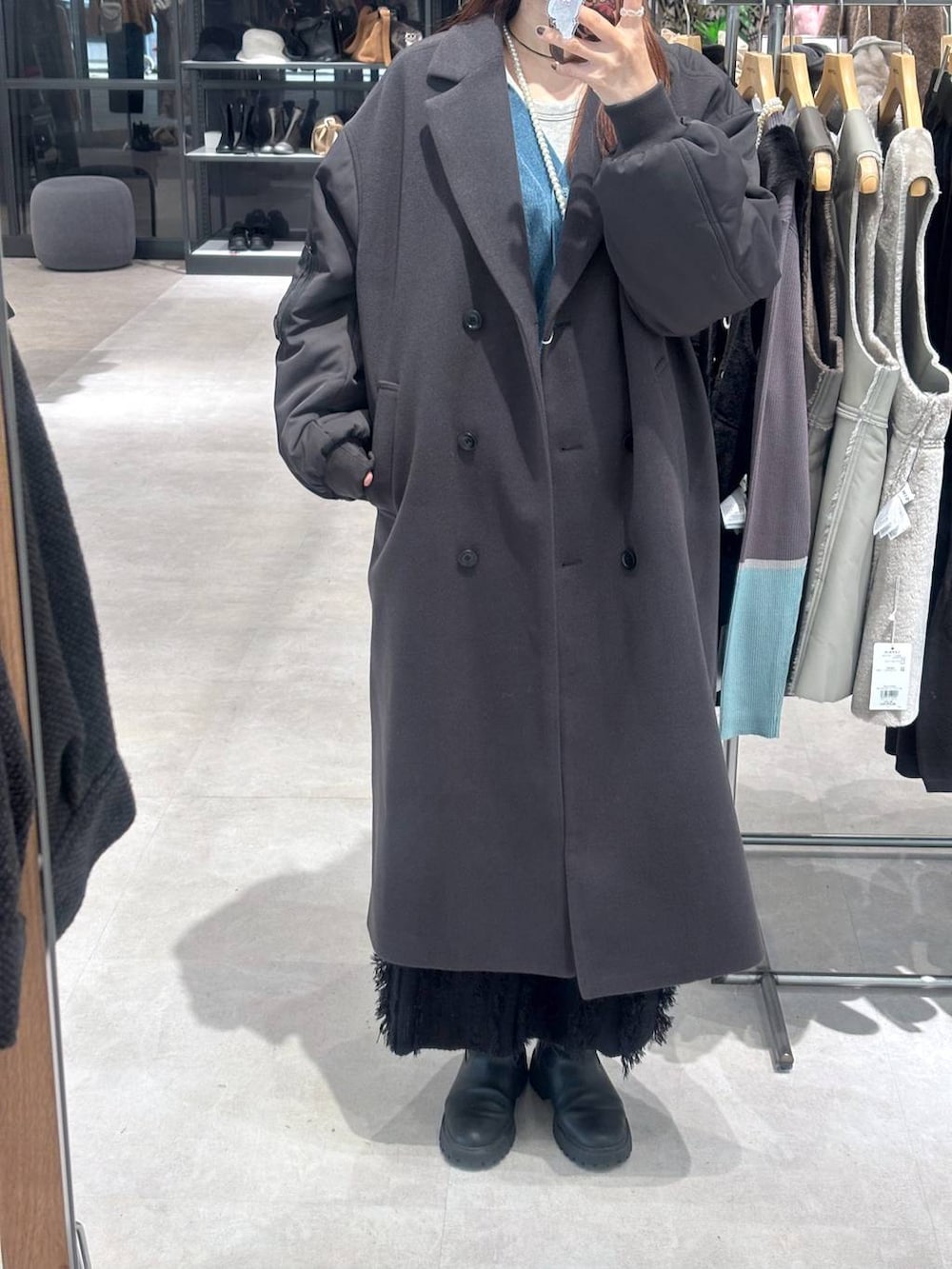 ブラック系のスカート、ブルー系のカーディガン/ボレロ、グレー系のその他アウターを着用したレディースの秋コーディネートの2枚目の写真