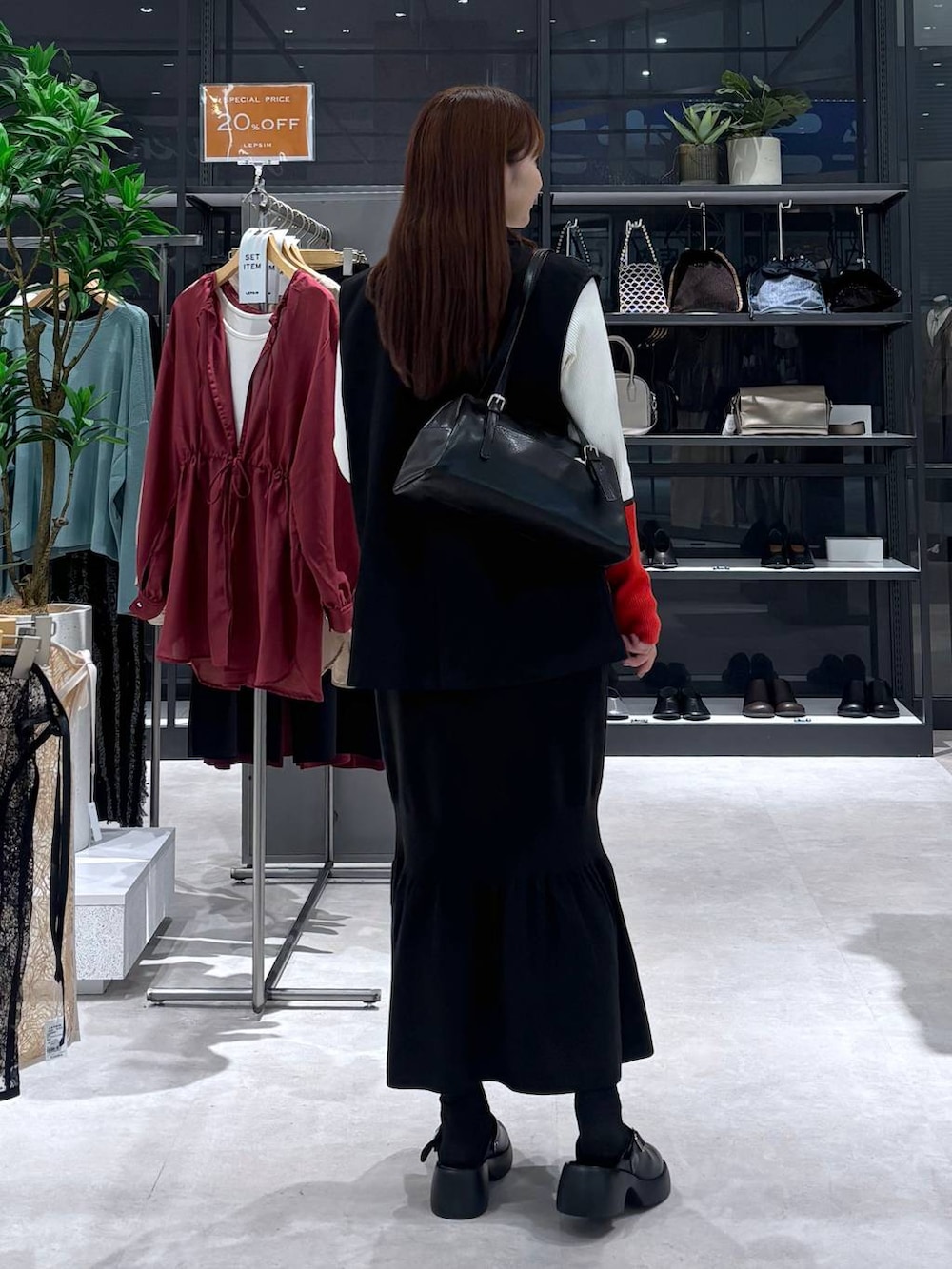 ブラック系のスカート、ホワイト系のニット/セーター、ブラック系のサンダルを着用したレディースの秋コーディネートの4枚目の写真