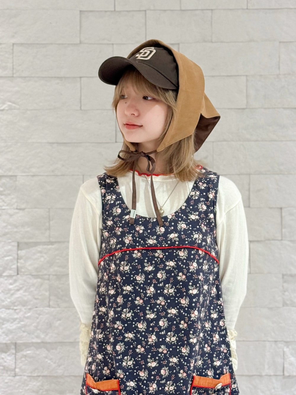 ホワイト系のTシャツ/カットソー、レッド系のパンツ、ブルー系のワンピースを着用したレディースの秋コーディネートの2枚目の写真