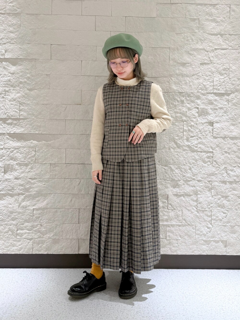 ブルー系のベスト、ブルー系のスカート、ブラック系のドレスシューズを着用したレディースの冬コーディネートの3枚目の写真