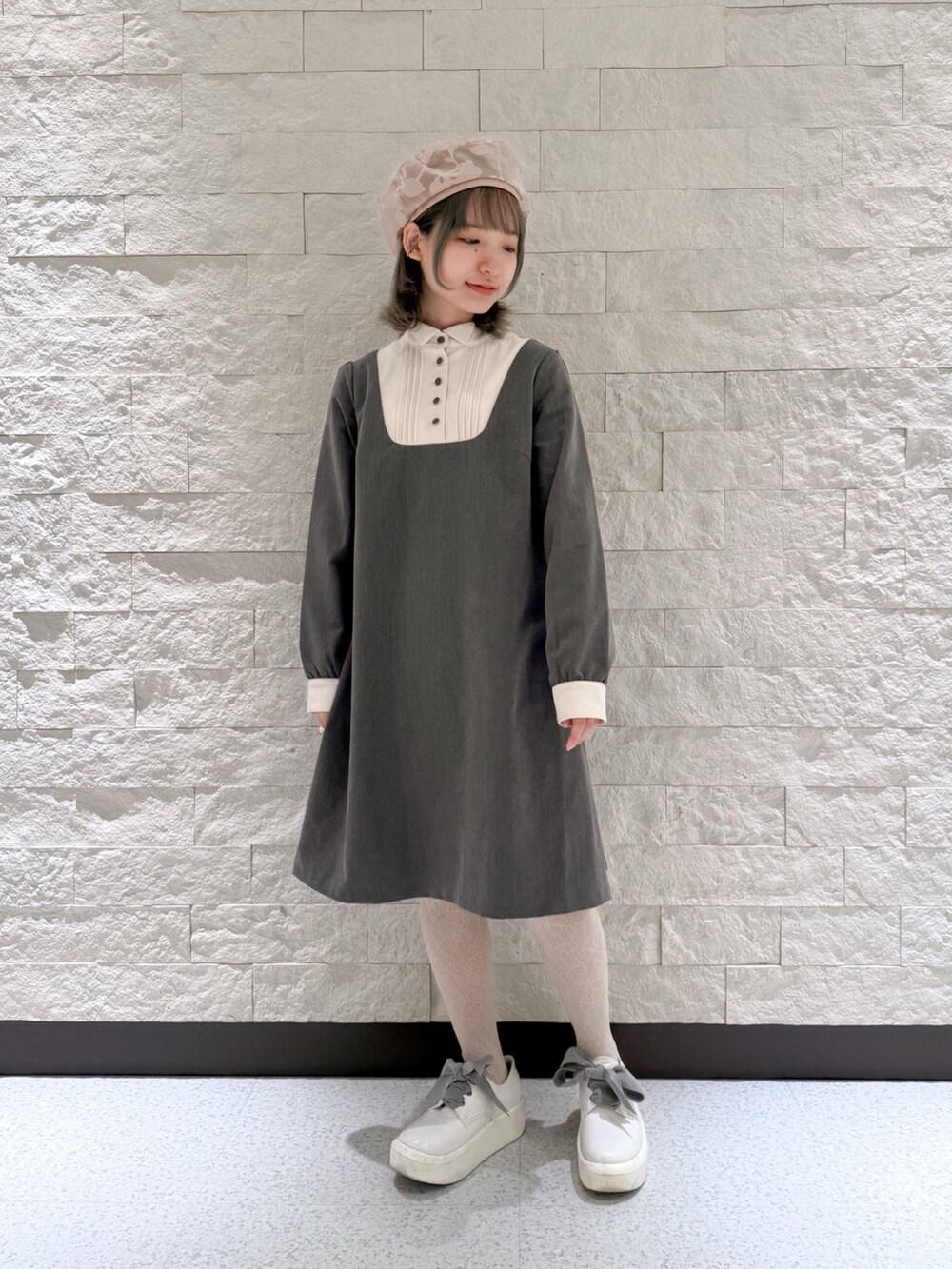 グレー系のワンピース、ホワイト系のシューズ、ピンク系のハンチング/ベレー帽を着用したレディースの春コーディネートの3枚目の写真