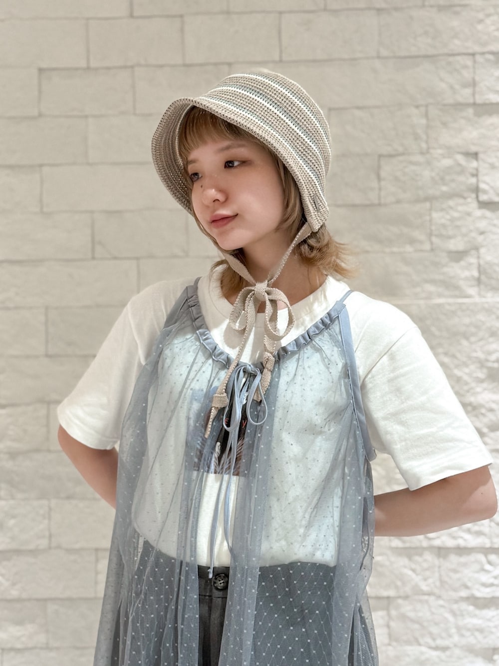 グレー系のパンツ、グレー系のスニーカー、ブラウン系のハットを着用したレディースの夏コーディネートの6枚目の写真