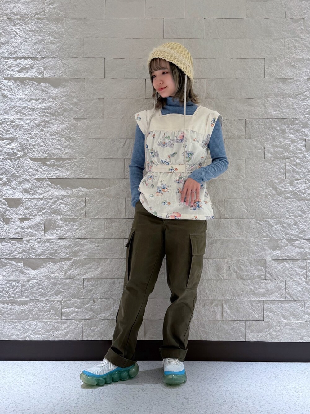 ブルー系のニット/セーター、その他のベスト、グリーン系のカーゴパンツを着用したレディースの春コーディネートの6枚目の写真