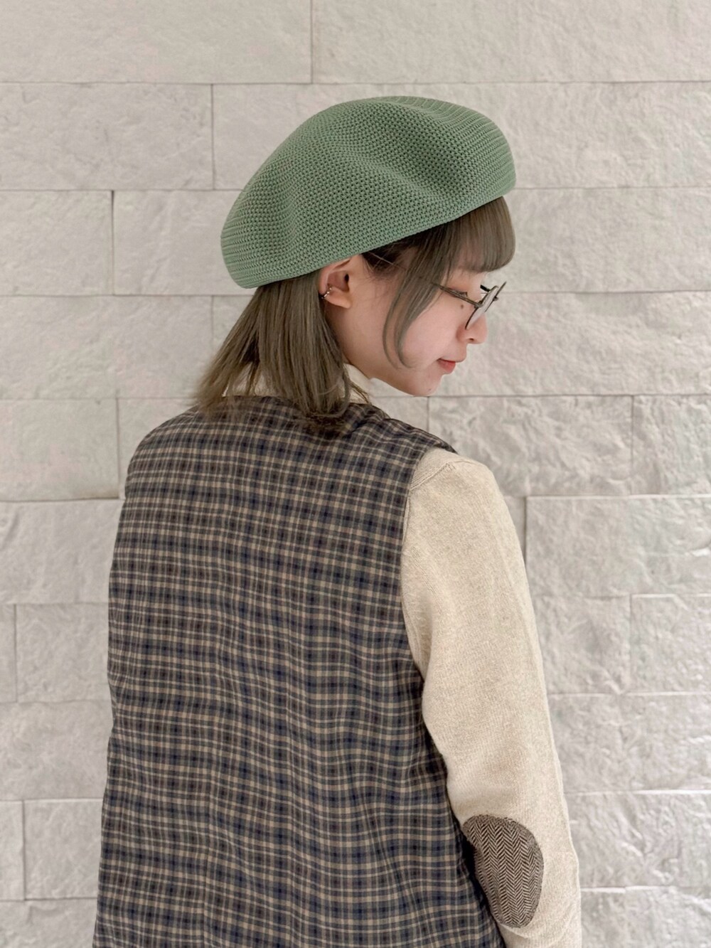 ブルー系のベスト、ブルー系のスカート、ブラック系のドレスシューズを着用したレディースの冬コーディネートの4枚目の写真