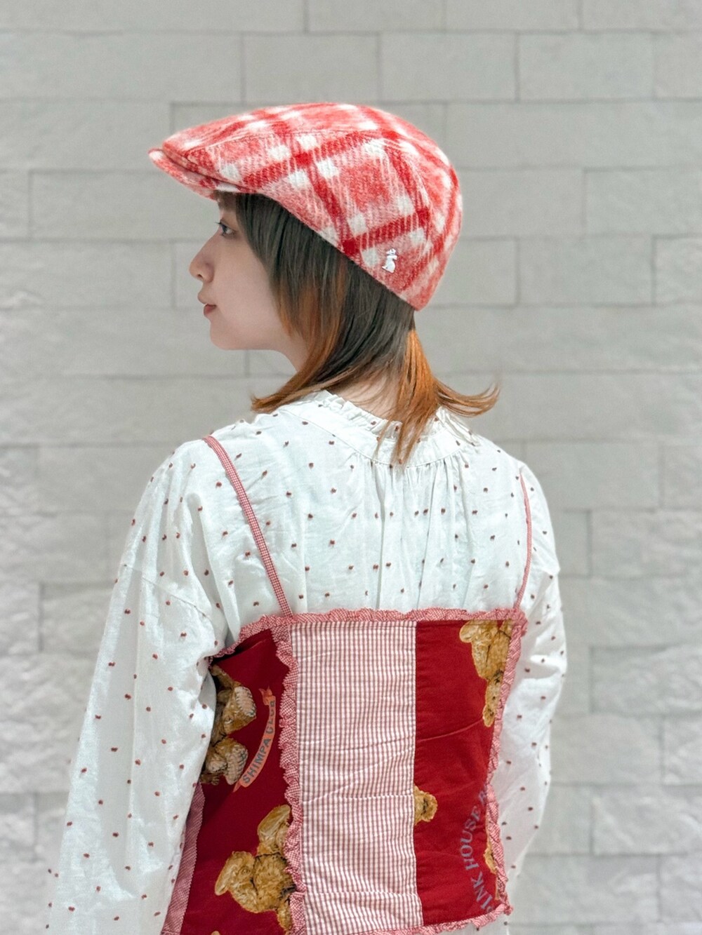 レッド系のベスト、ホワイト系のワンピース、ブラウン系のサンダルを着用したレディースの秋コーディネートの8枚目の写真