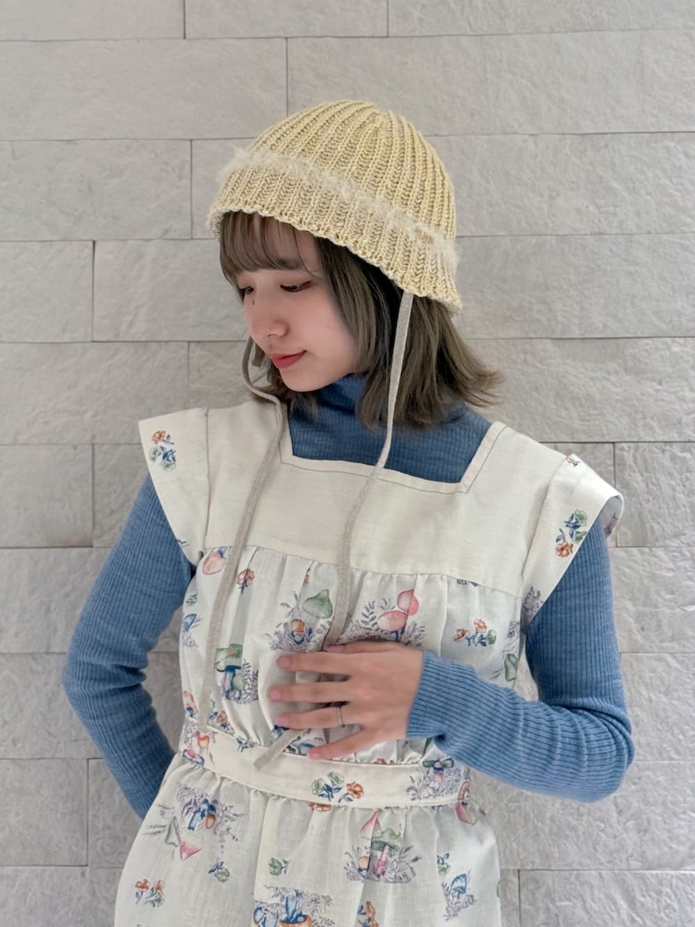 ブルー系のニット/セーター、その他のベスト、グリーン系のカーゴパンツを着用したレディースの春コーディネートの2枚目の写真