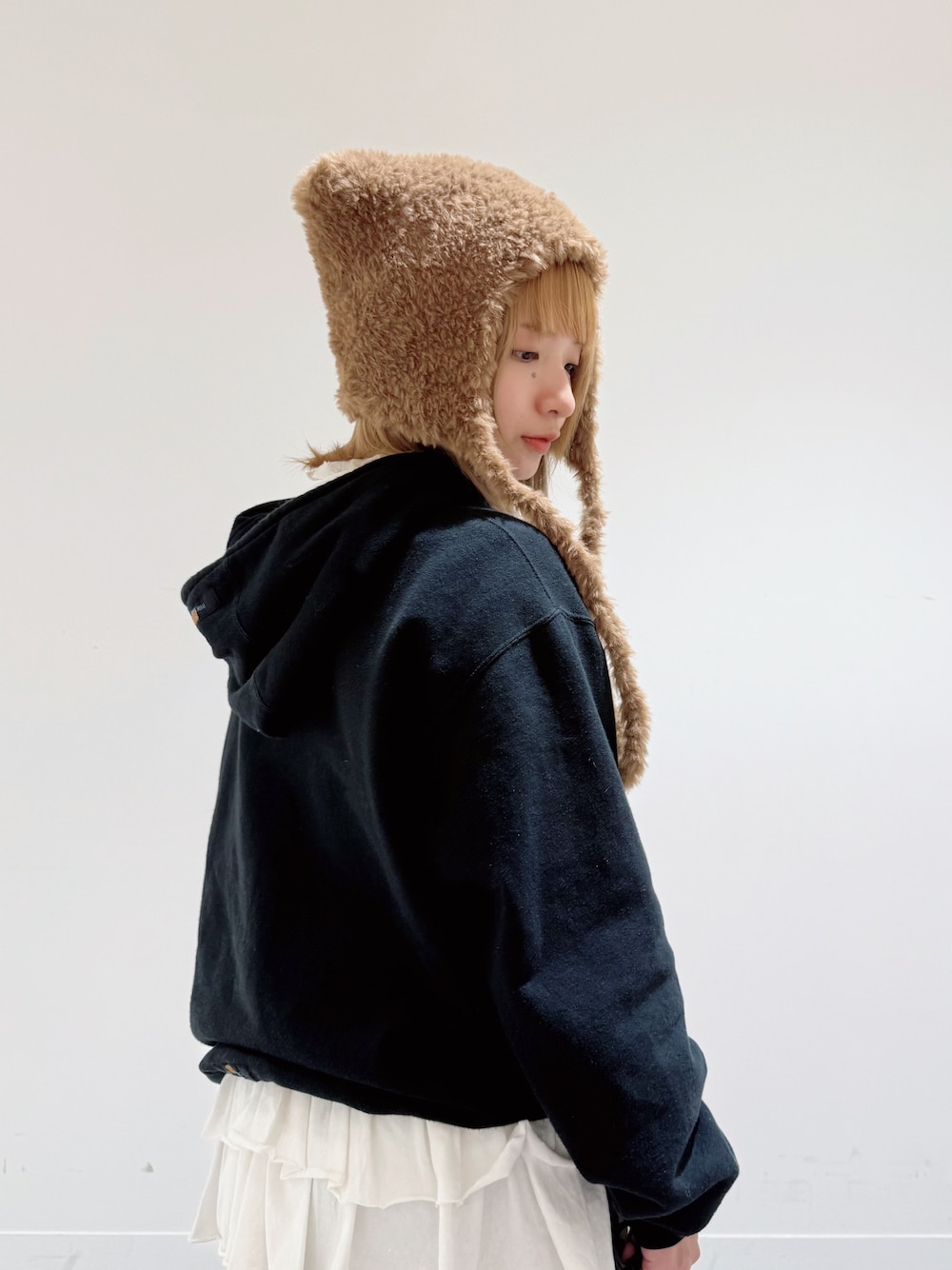 ブラック系のパーカー、ブルー系のパンツ、ブラック系のスニーカーを着用したレディースの冬コーディネートの3枚目の写真