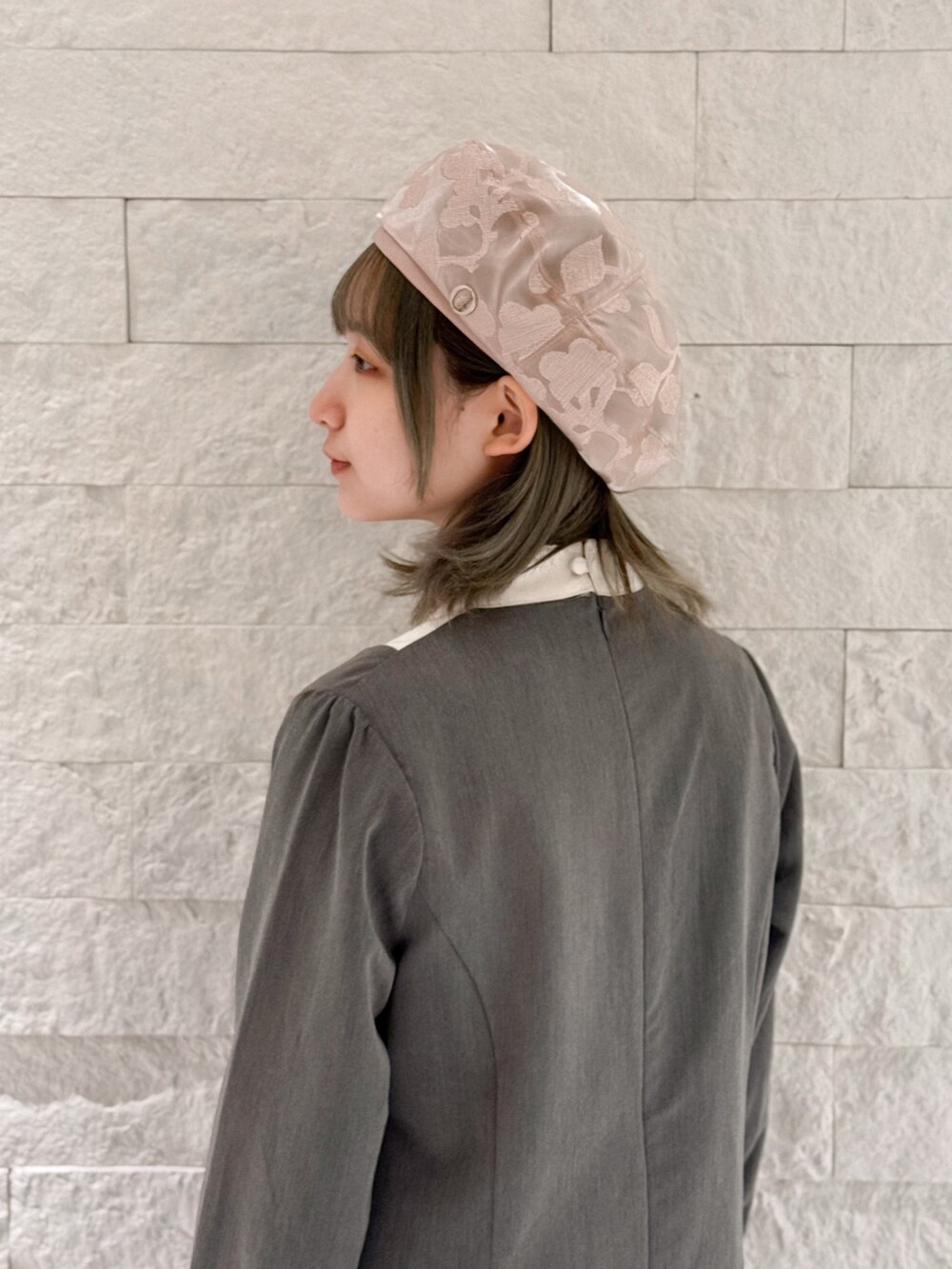 グレー系のワンピース、ホワイト系のシューズ、ピンク系のハンチング/ベレー帽を着用したレディースの春コーディネートの5枚目の写真