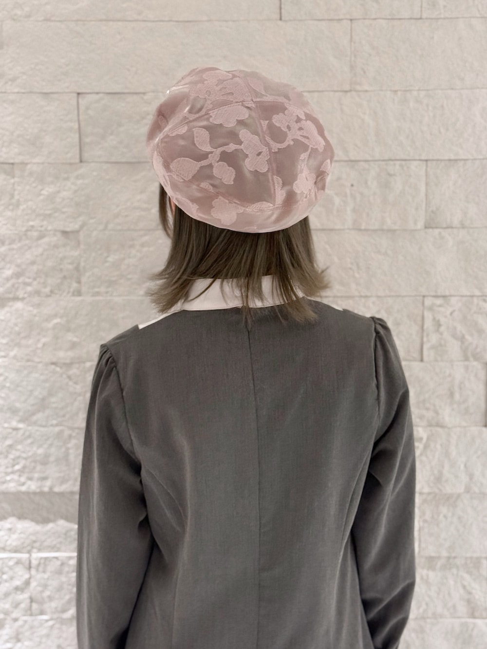 グレー系のワンピース、ホワイト系のシューズ、ピンク系のハンチング/ベレー帽を着用したレディースの春コーディネートの6枚目の写真