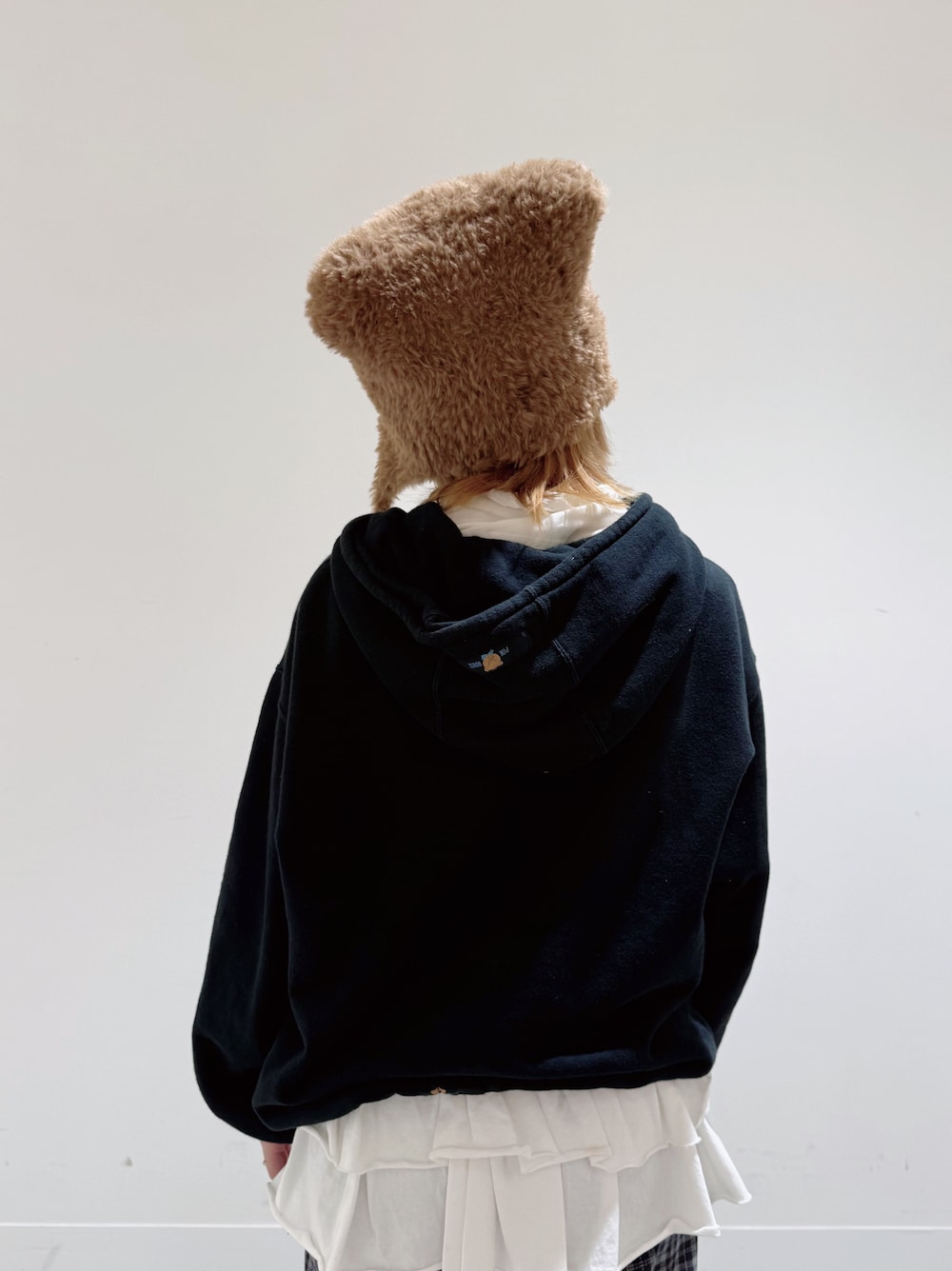 ブラック系のパーカー、ブルー系のパンツ、ブラック系のスニーカーを着用したレディースの冬コーディネートの4枚目の写真