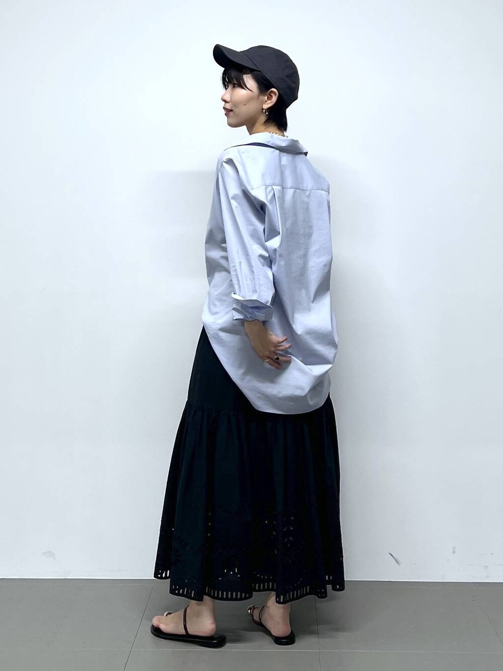 ブラック系のサンダル、ブラック系のハンドバッグ、ブルー系のシャツ/ブラウスを着用したレディースの夏コーディネートの3枚目の写真