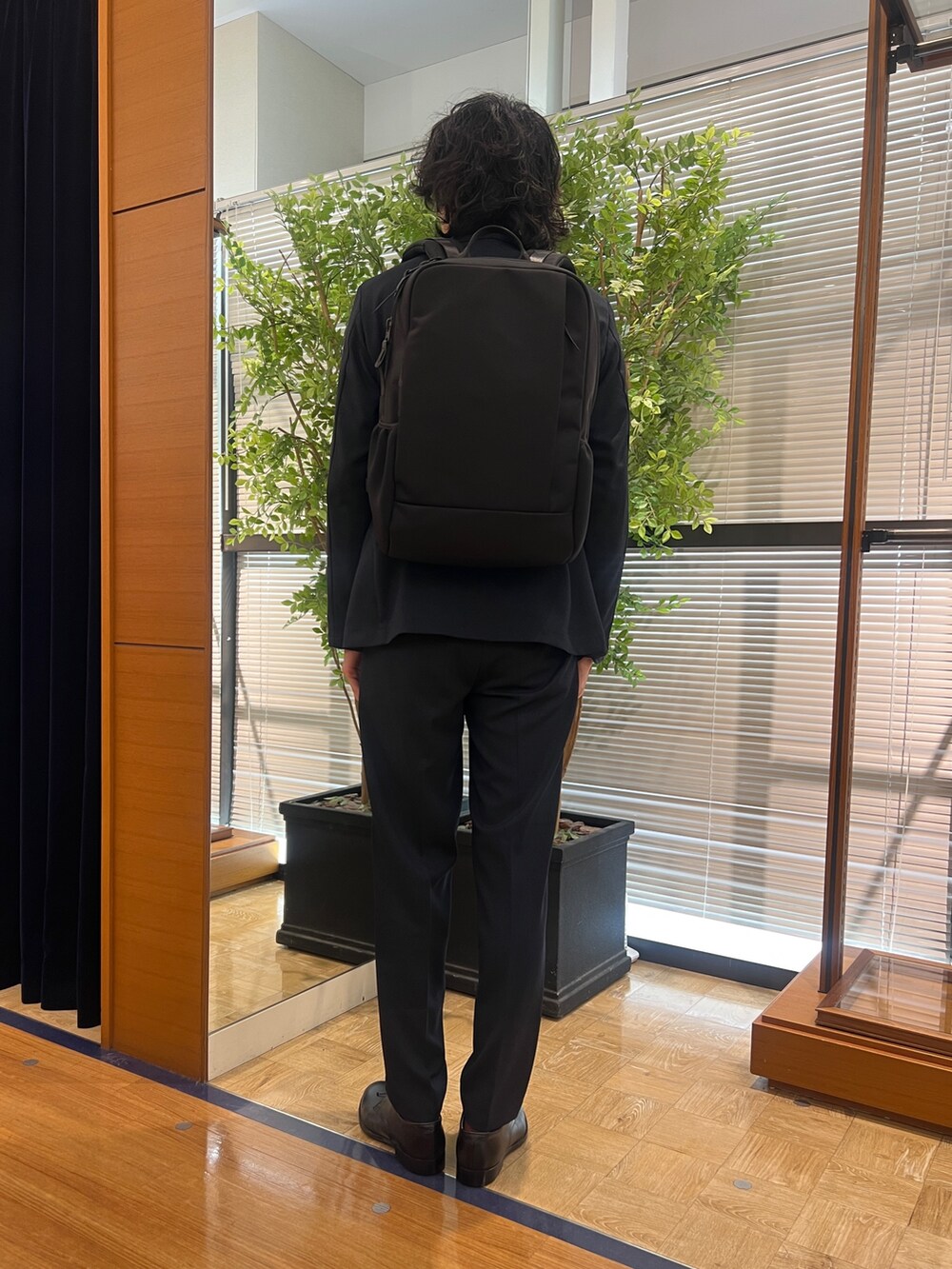 ブルー系のテーラードジャケット、ブルー系のシャツ/ブラウス、ブラック系のバックパック/リュックを着用したメンズの冬コーディネートの5枚目の写真