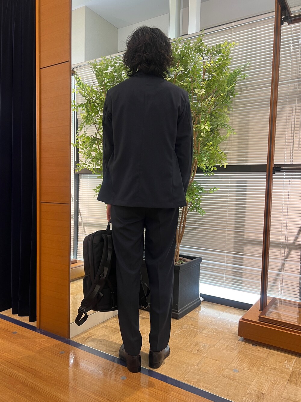 ブルー系のテーラードジャケット、ブルー系のシャツ/ブラウス、ブラック系のバックパック/リュックを着用したメンズの冬コーディネートの4枚目の写真