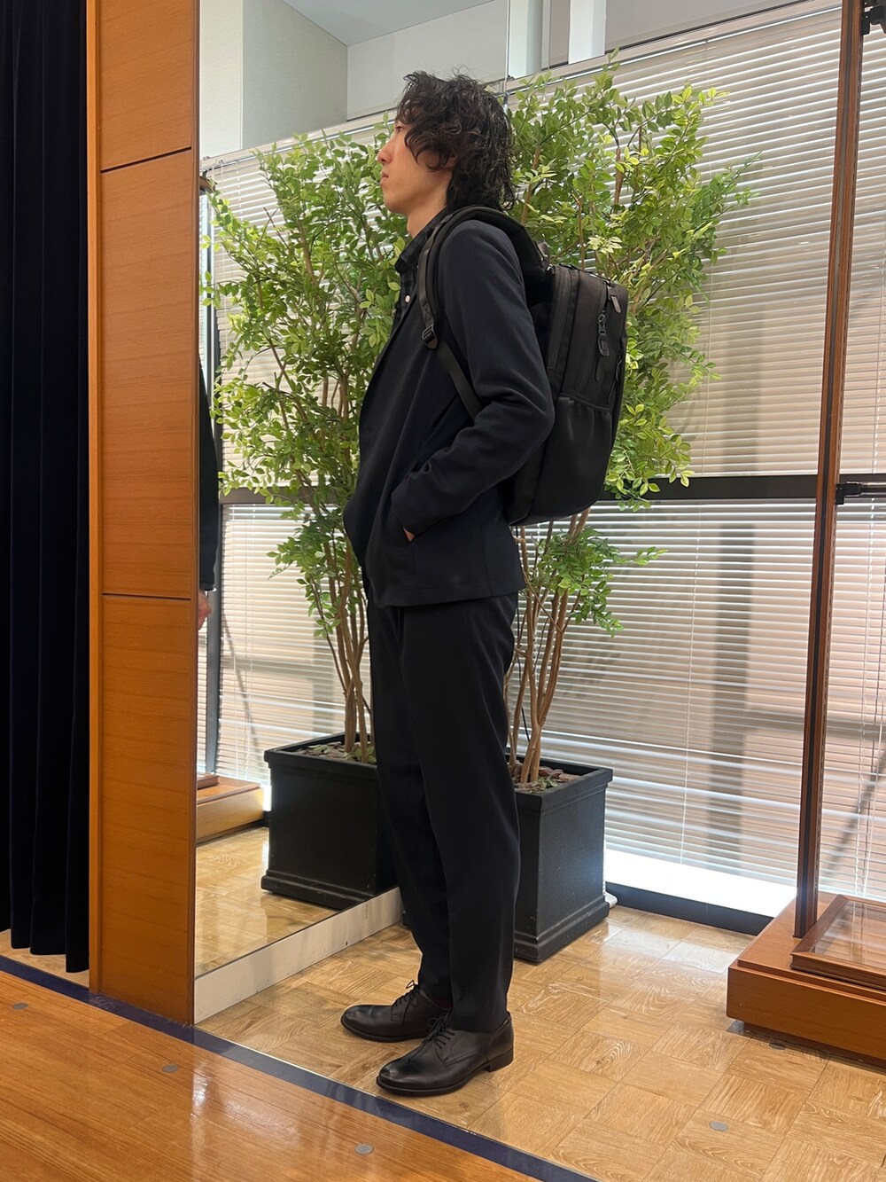 ブルー系のテーラードジャケット、ブルー系のシャツ/ブラウス、ブラック系のバックパック/リュックを着用したメンズの冬コーディネートの3枚目の写真