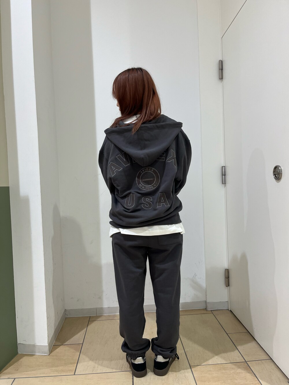 グレー系のパーカー、ホワイト系のTシャツ/カットソー、グレー系のスウェットパンツを着用したレディースの秋コーディネートの2枚目の写真