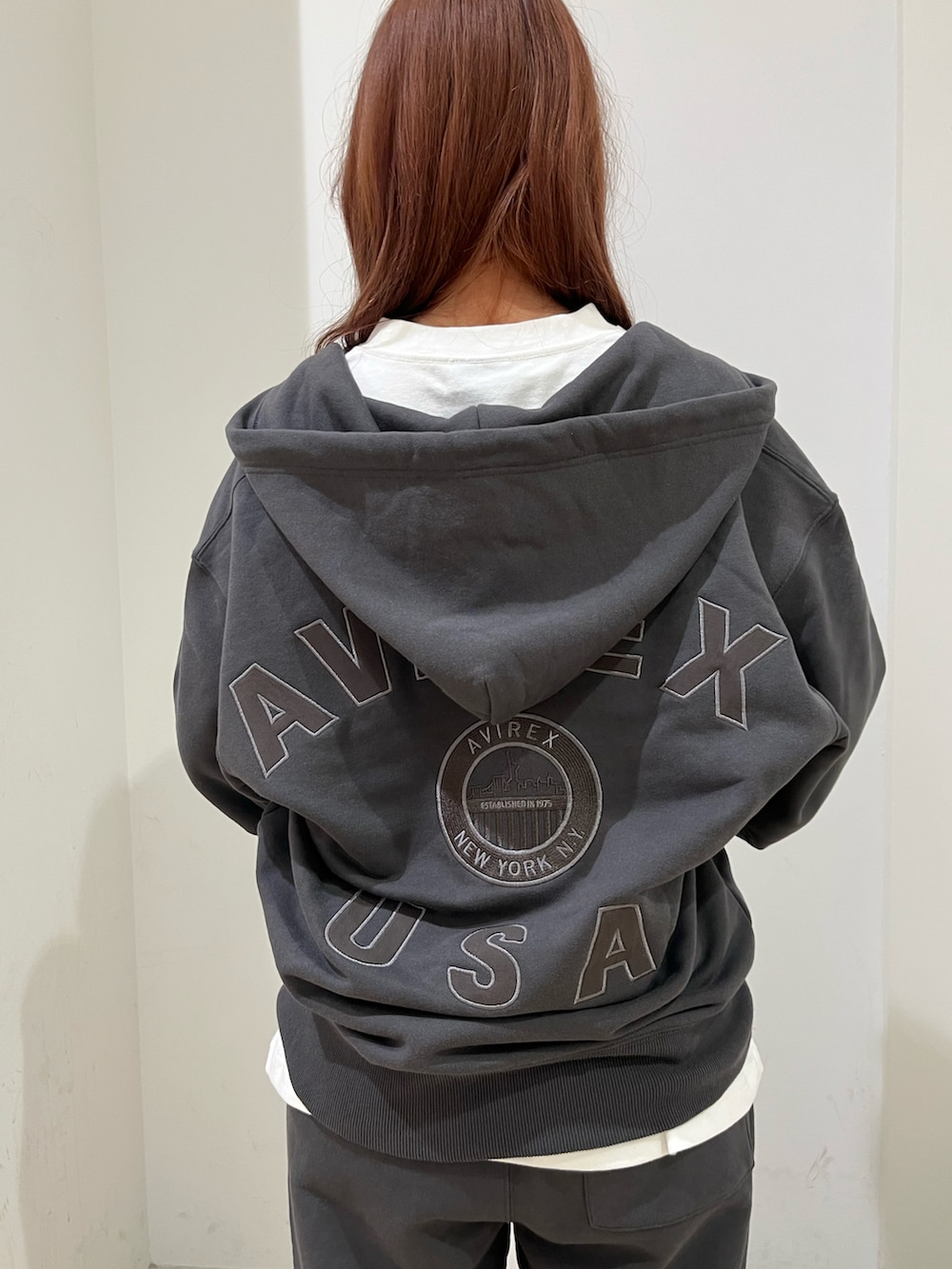 グレー系のパーカー、ホワイト系のTシャツ/カットソー、グレー系のスウェットパンツを着用したレディースの秋コーディネートの3枚目の写真