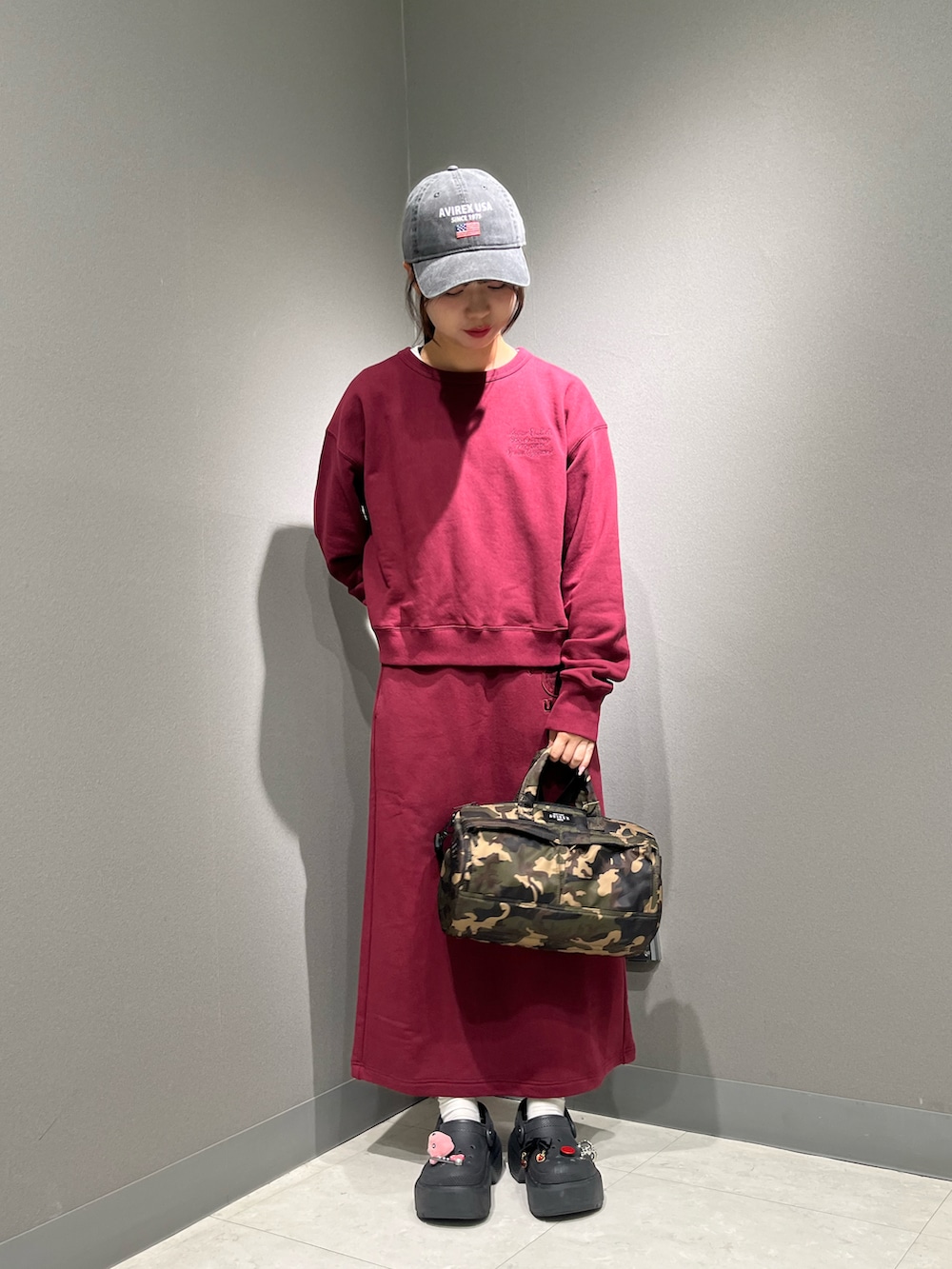 レッド系のスウェット、ホワイト系のTシャツ/カットソー、その他のボストンバッグを着用したレディースの秋コーディネートの2枚目の写真