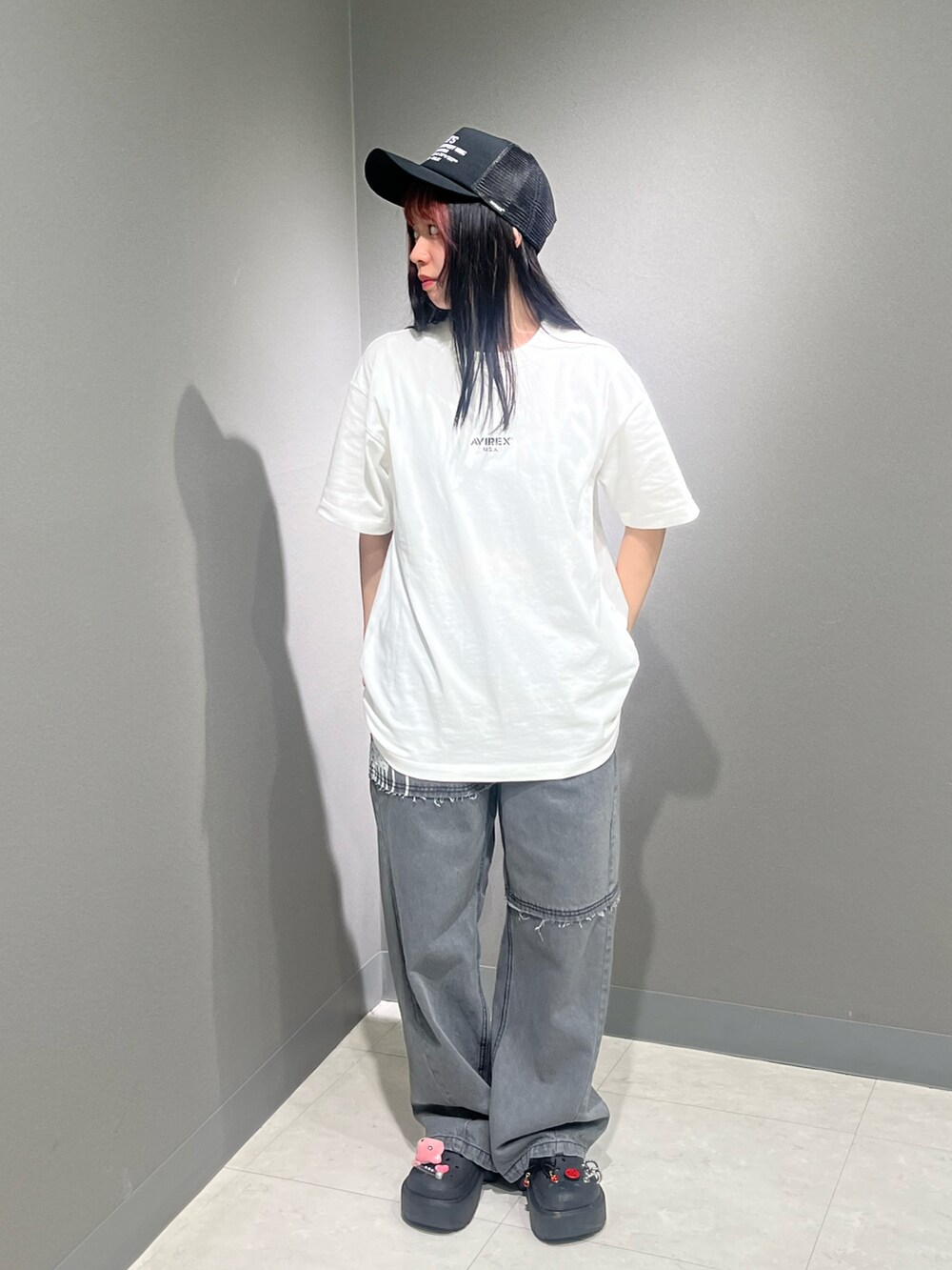 ホワイト系のTシャツ/カットソー、ブラック系のデニムパンツ、ブラック系のキャップを着用したレディースの春コーディネートの2枚目の写真