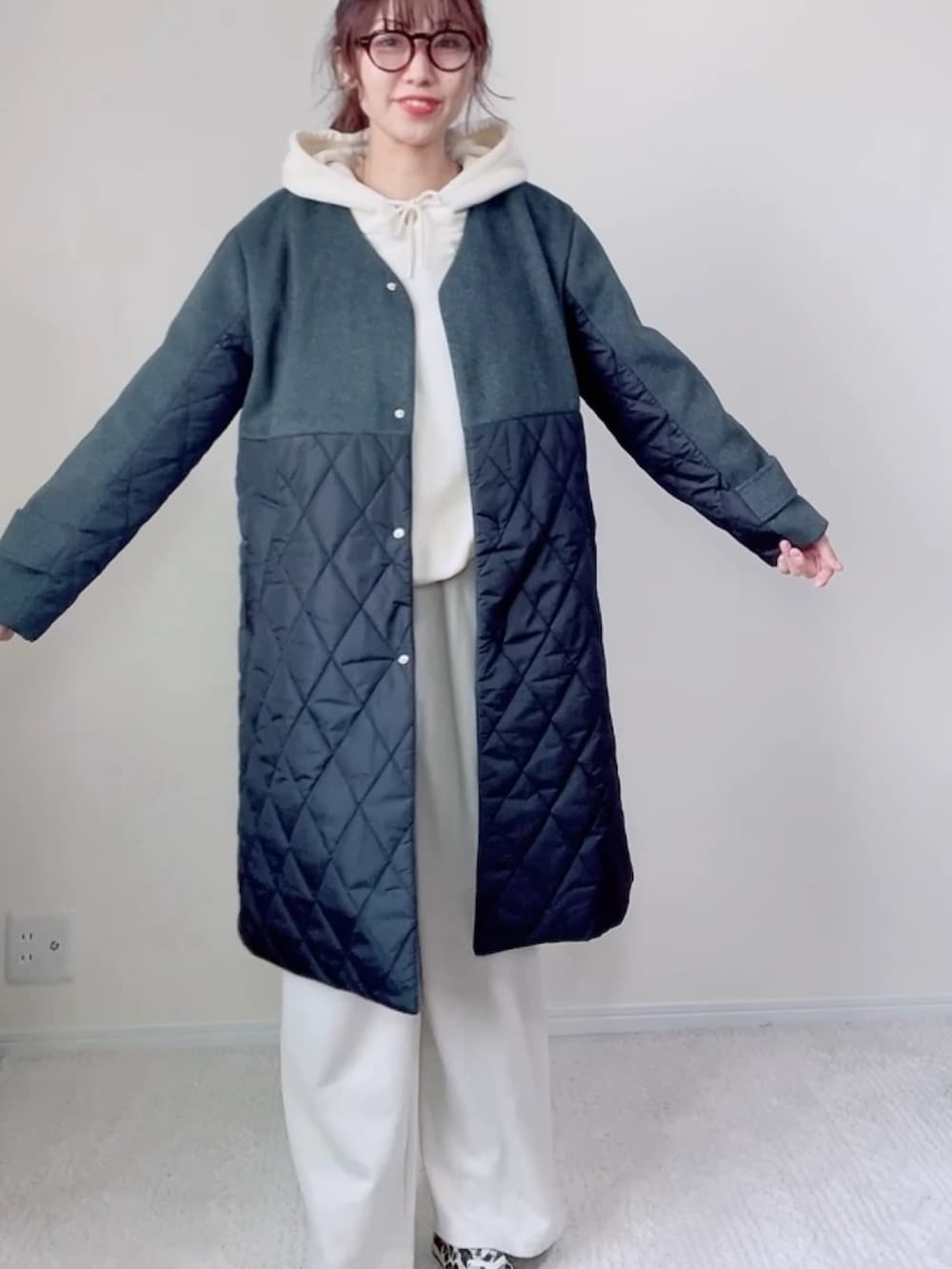 ホワイト系のパンツ、ブラック系のノーカラーコート、ホワイト系のパーカーを着用したレディースの秋コーディネートの2枚目の写真