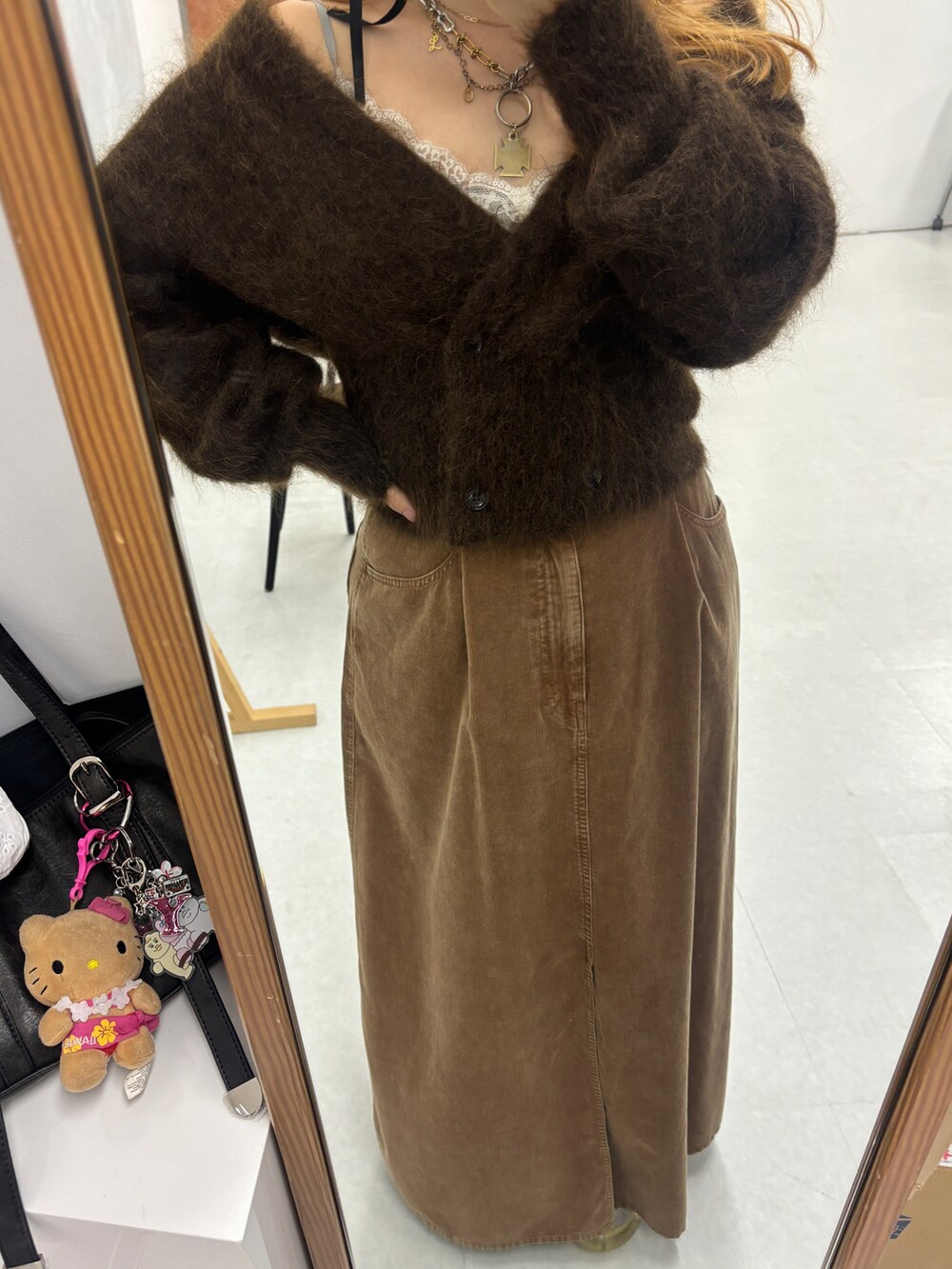 ブラウン系のカーディガン/ボレロ、イエロー系のスカート、ゴールド系のネックレスを着用したレディースの秋コーディネートの4枚目の写真