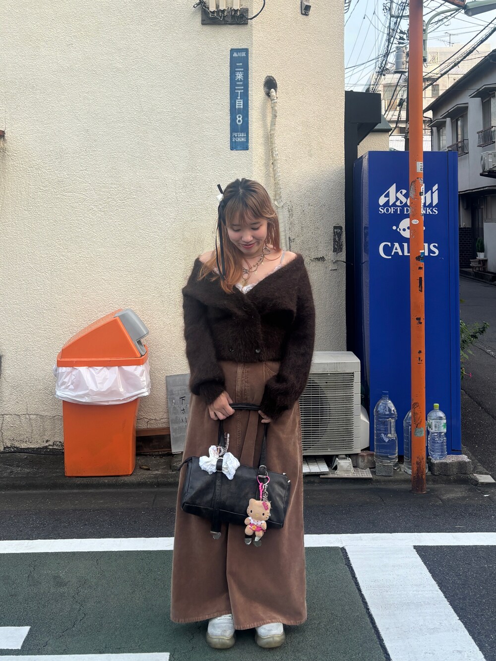 ブラウン系のカーディガン/ボレロ、イエロー系のスカート、ゴールド系のネックレスを着用したレディースの秋コーディネートの2枚目の写真