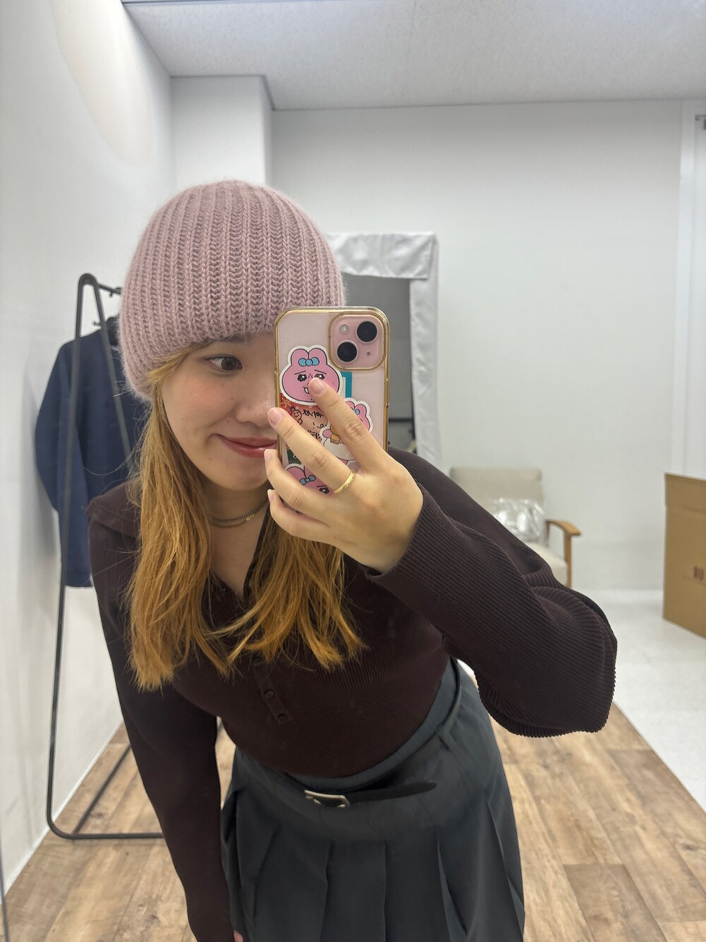 グレー系のスカート、ブラウン系のニット/セーターを着用したレディースの秋コーディネートの2枚目の写真