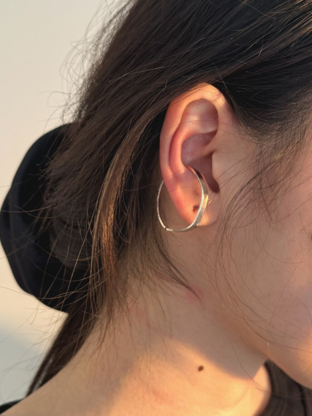 ブラック系のTシャツ/カットソー、グレー系のスカート、シルバー系のイヤーカフを着用したレディースの秋コーディネートの4枚目の写真