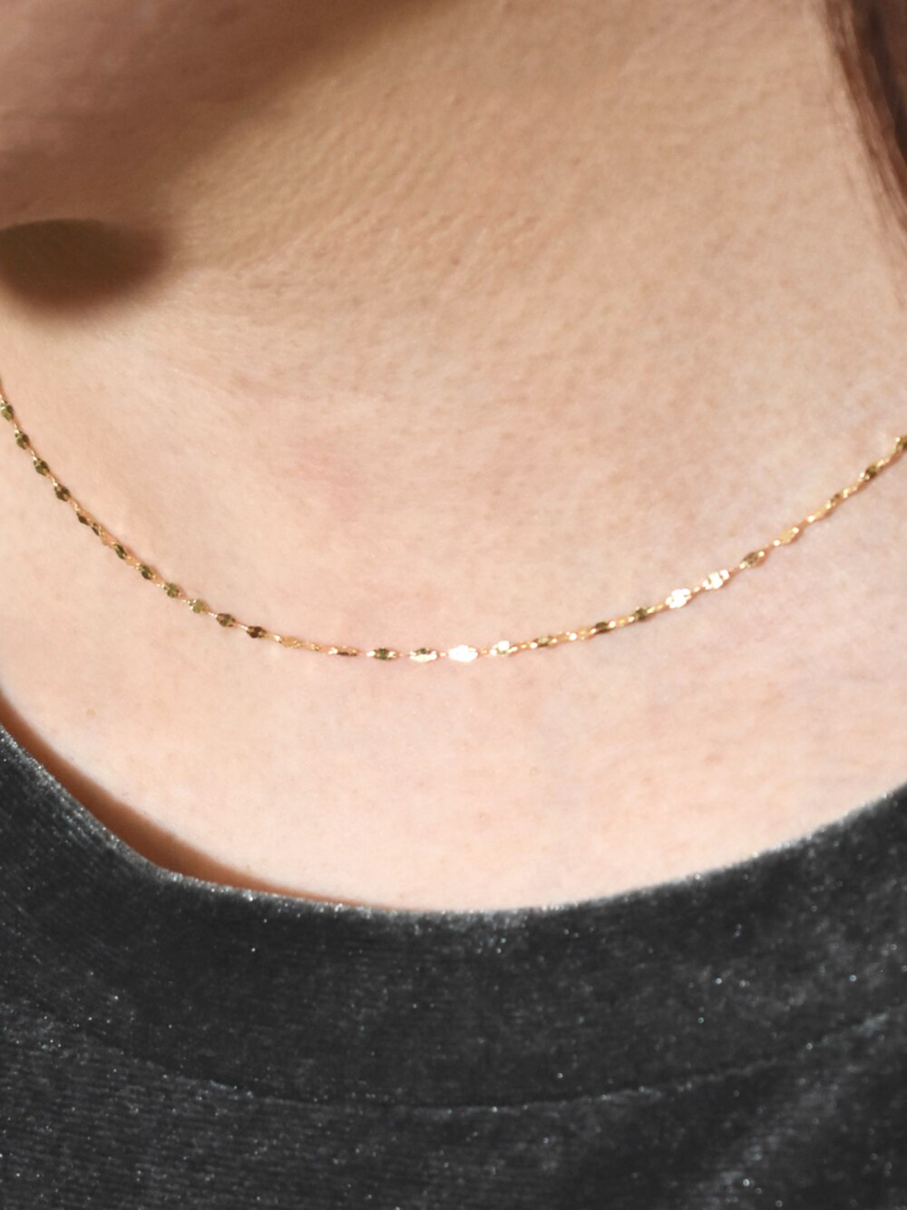 ブラック系のスカート、グレー系のTシャツ/カットソー、ゴールド系のネックレスを着用したレディースの秋コーディネートの2枚目の写真