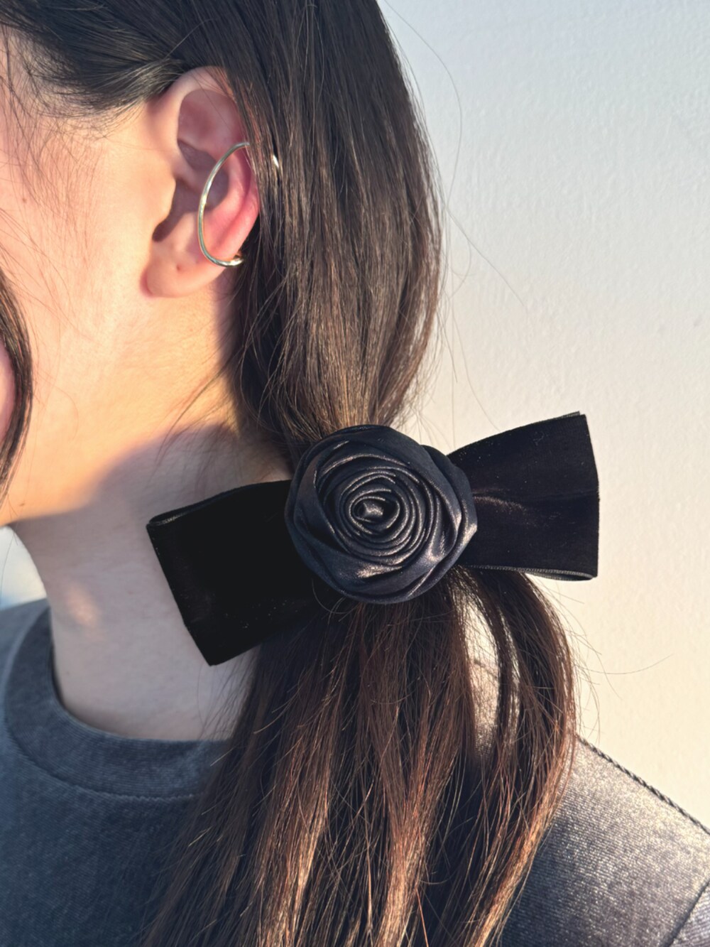 ブラウン系のスカート、グレー系のTシャツ/カットソー、シルバー系のイヤーカフを着用したレディースの秋コーディネートの2枚目の写真