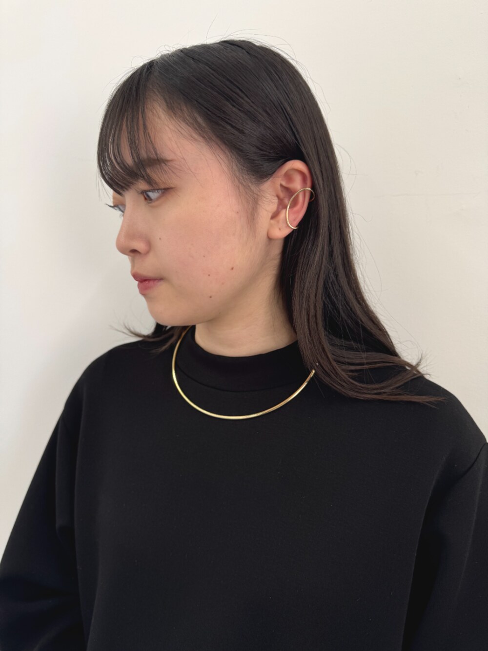 ブルー系のワンピース、ブラック系のスウェット、ゴールド系のネックレスを着用したレディースの冬コーディネートの2枚目の写真