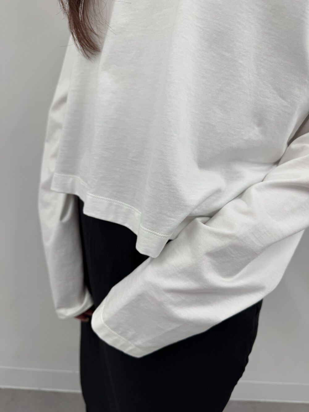 ブラック系のスカート、ホワイト系のTシャツ/カットソーを着用したレディースの春コーディネートの3枚目の写真