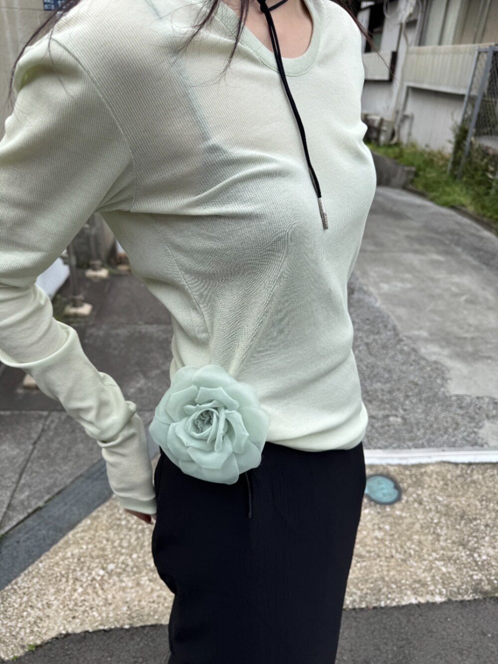 ブラック系のスカート、グリーン系のTシャツ/カットソー、シルバー系のネックレスを着用したレディースの春コーディネートの4枚目の写真