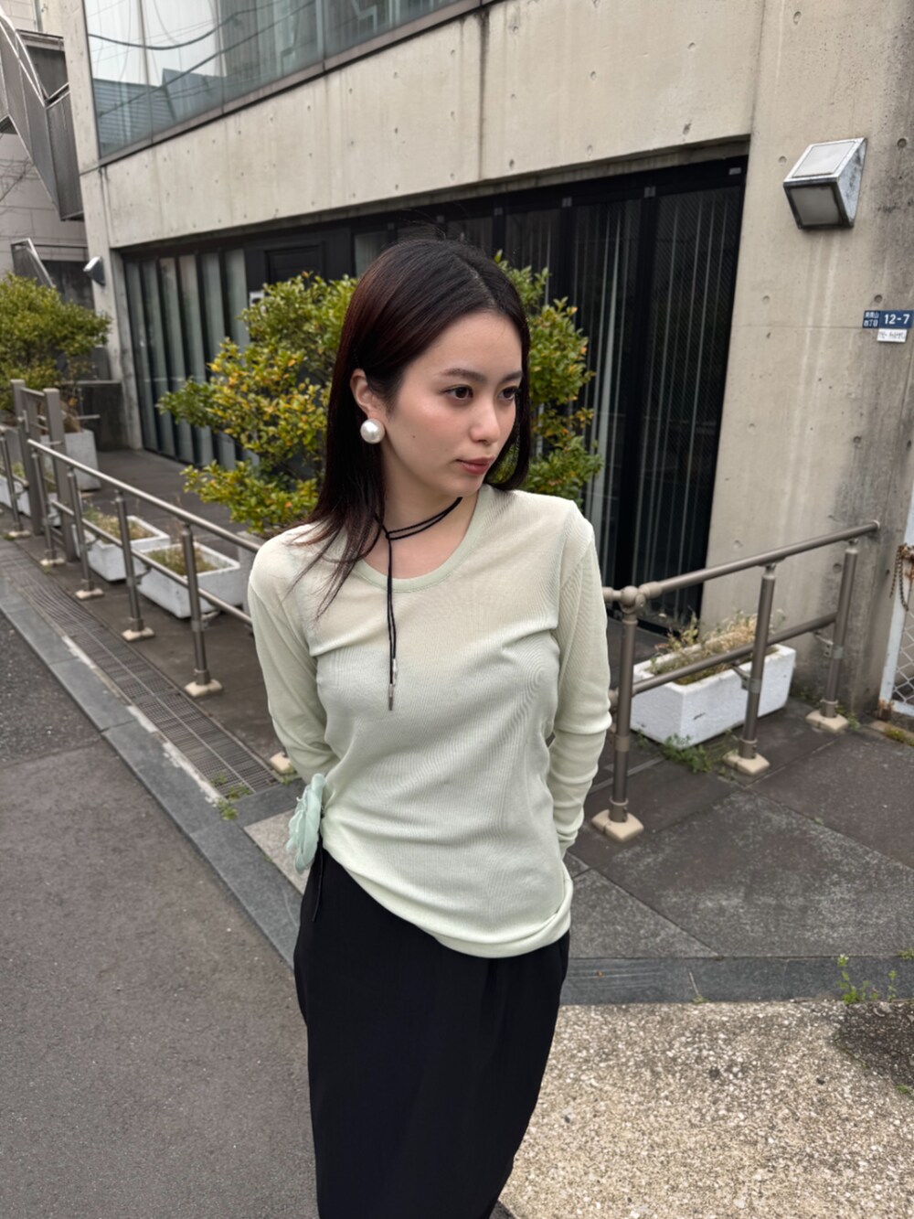 ブラック系のスカート、グリーン系のTシャツ/カットソー、シルバー系のネックレスを着用したレディースの春コーディネートの3枚目の写真