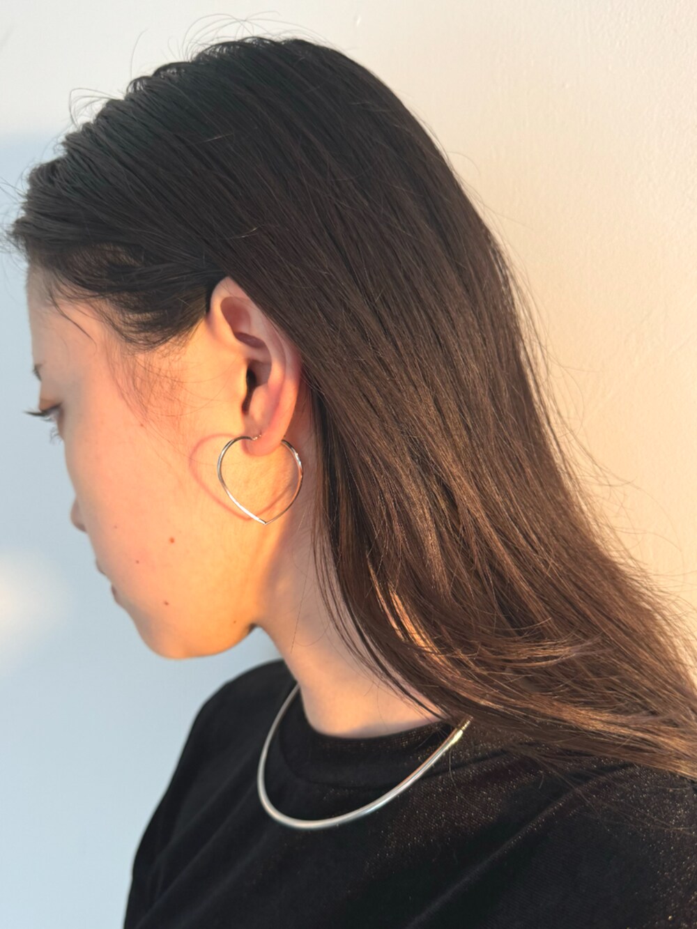 ブラック系のスカート、ブラック系のTシャツ/カットソー、シルバー系のネックレスを着用したレディースの秋コーディネートの3枚目の写真