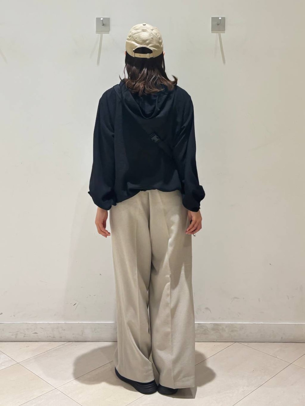 ベージュ系のその他パンツ、ブラック系のマウンテンパーカー、ブラック系のスニーカーを着用したレディースの春コーディネートの4枚目の写真