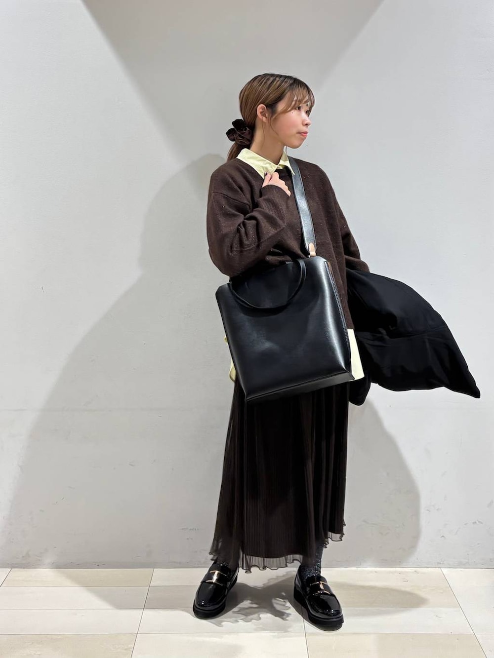 ブラック系のローファー、ブラック系のトートバッグ、ホワイト系のブルゾンを着用したレディースの秋コーディネートの5枚目の写真